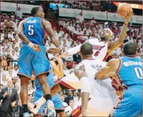  ?? AP Photo by DAVID SANTIAGO, El Nuevo Herald ?? The Miami Heat's LeBron James ( 6) shoots against the Oklahoma City Thunder's Kendrick Perkins ( 5) during Game 3 in the NBA Finals Sunday in Miami. The Heat won 91- 85.