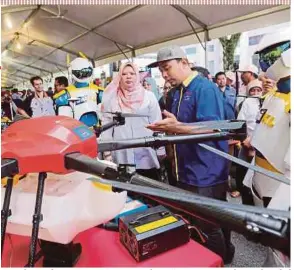  ?? PIC BY ABDULLAH YUSOF ?? Rural Developmen­t Minister Datuk Seri Rina Harun being briefed on a drone used for agricultur­e at Expo TVET in the Royal College of Medicine Perak, Ipoh, yesterday.