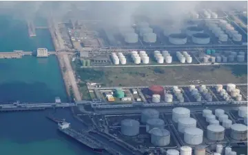  ?? — Reuters ?? Oil and gas tanks are seen at an oil warehouse at a port in Zhuhai, China.