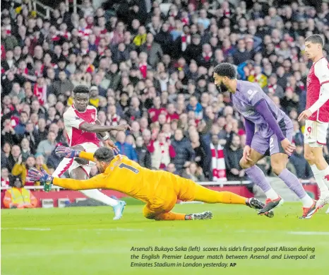  ?? AP ?? Arsenal’s Bukayo Saka (left) scores his side’s first goal past Alisson during the English Premier Leaguer match between Arsenal and Liverpool at Emirates Stadium in London yesterday.