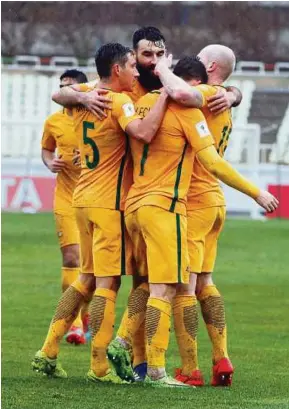  ??  ?? Australia’s Mathew Leckie (second from right) celebrates with his teammates after scoring against Iraq on Thursday.