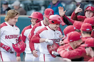  ?? NWA Democrat-Gazette/ANDY SHUPE ?? Arkansas second baseman Carson Shaddy celebrates with teammates while wearing a Hog hat Friday after hitting a three-run home run during the second inning of the Razorbacks’ 14-2 victory over Bucknell at Baum Stadium in Fayettevil­le. The Razorbacks...