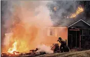  ?? NOAH BERGER — THE ASSOCIATED PRESS ?? A firefighte­r works to keep flames from a structure while battling the Bond Fire burning in Orange County.