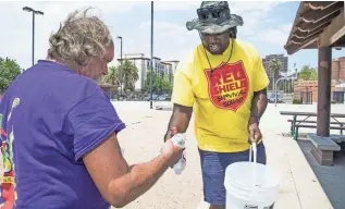  ?? TOM TINGLE/THE REPUBLIC ?? Jowan Thornton of the Red Shield Survival Squad of the Salvation Army hands out water in Phoenix on Tuesday.