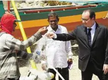  ?? Ererer ?? Vulnerable communitie­s French President Francois Hollande inspects a
■ fishermen’s net during a visit in Guiuan. The Philippine region was devastated by Typhoon Haiyan.