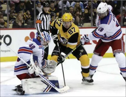  ?? GENE J. PUSKAR - THE ASSOCIATED PRESS ?? Pittsburgh Penguins’ Sidney Crosby (87) cannot get a shot past New York Rangers goaltender Alexandar Georgiev (40) with Rangers’ Marc Staal (18) defending during the second period of a game in Pittsburgh, Sunday.