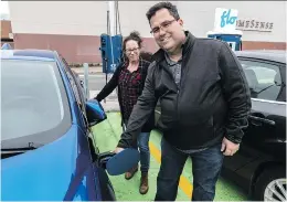  ?? DAVE SIDAWAY ?? Eric Besner and his wife France Therrien charge up their new Chevy Volt at a FLO station at Fairview shopping centre in Pointe-Claire.