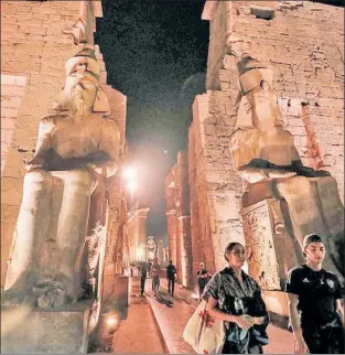  ?? ?? STROLL BACK IN TIME: Visitors on Thursday walk past Egypt’s Temple of Luxor, built around 1400 B.C., after the official ceremony opening the 1.6-mile “Rams Road.”