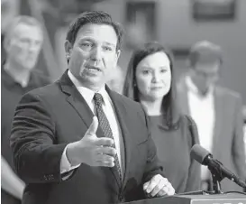  ?? CALVIN KNIGHT/THE LEDGER ?? Florida Gov. Ron DeSantis is seen with state Attorney General Ashley Moody. Florida is one of 14 states that plan to sue over President Biden’s vaccine mandate.