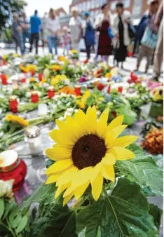  ?? Foto: Bodo Marks, dpa ?? Während viele Menschen am Schauplatz der Messeratta­cke in Hamburg Barmbek Blumen niederlege­n, streitet die Politik über Abschieber­egeln.