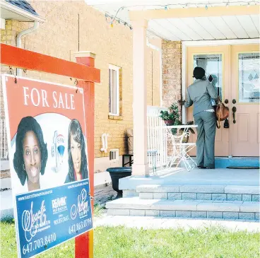  ?? MARK SOMMERFELD / BLOOMBERG NEWS ?? A real estate agent with an open house sign in Brampton, Ont.