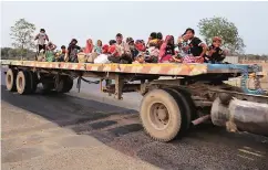  ?? PHOTO: REUTERS ?? Migrant workers and their families travel in a trailer truck as they return to their villages, on the outskirts of Ahmedabad on Sunday