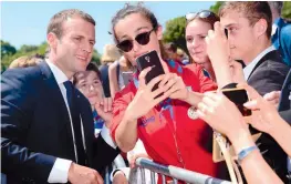  ?? —AFP ?? French President Emmanuel Macron poses for a selfie with a woman during the ceremony to mark the 77th anniversar­y of late French General Charles de Gaulle’s appeal of June 18, 1940, in Suresnes, outside of Paris, on Sunday.