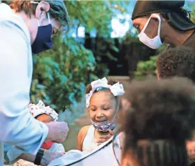  ??  ?? RedRose Baldwin, 6, watches the release of a butterfly during a sneak preview of the reopening of the Puelicher Butterfly Wing at the Milwaukee Public Museum on Wednesday. Also pictured are museum President and CEO Ellen Censky, left, and RedRose’s dad, Tyrone Brown II.