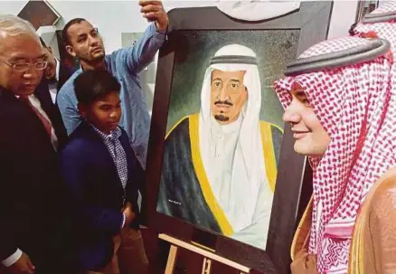  ??  ?? Mahdzir menyampaik­an cenderamat­a, iaitu potret Raja Salman Abdulaziz Al-saud yang dilukiskan pelukis cilik dari Sekolah Seni Johor, Naim Hamid Hamidin kepada Menteri Penerangan Arab Saudi, Dr Adel Zaid altoraifi (kanan).