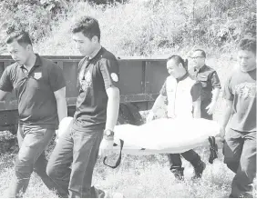  ??  ?? ANGGOTA polis mengangkat mayat mangsa ke rumah mayat Hospital Limbang untuk bedah siasat.