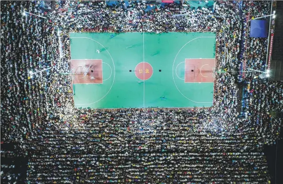  ?? ZHANG KUI / FOR CHINA DAILY ?? Thousands of spectators watch a local basketball game at an open-air venue in Taijiang county, Southwest China’s Guizhou province on Aug 2.