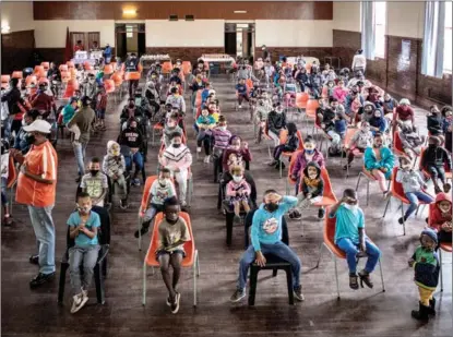  ?? LUCA SOLA / AFP ?? Children wait for handouts of food and other necessitie­s at the Coronation­ville Secondary School in Johannesbu­rg, South Africa, on Dec 23.