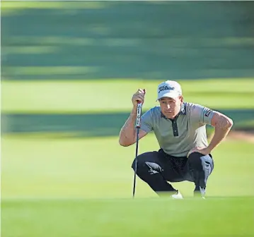  ??  ?? Brett Rumford lines up a putt during the first round yesterday.