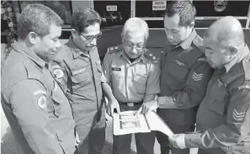  ??  ?? Five of the APM members who were on duty when Kota Kuala Muda was hit by the tsunami in 2004. Hasrul is at second right. — Bernama photo