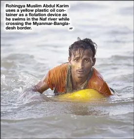  ?? AP ?? Rohingya Muslim Abdul Karim uses a yellow plastic oil container as a flotation device as he swims in the Naf river while crossing the Myanmar-Bangladesh border.