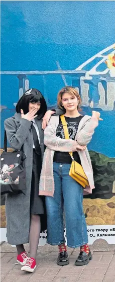  ?? Oleksii ?? Young women in Kyiv pose in front of a giant stamp hailing the Kerch bridge explosion last week
Picture