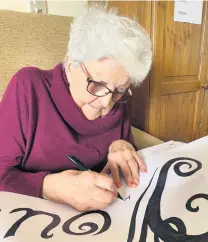  ??  ?? A Sutton Grange resident working on the banner they recently produced