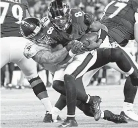  ?? KENNETH K. LAM/BALTIMORE SUN ?? Ravens quarterbac­k Lamar Jackson, right, is sacked by the Titans' Kamalei Correa, a former Raven, in the second quarter at M&T Bank Stadium on Saturday night.