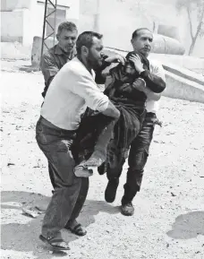  ?? AMEER ALHALBI, AFP/GETTY IMAGES ?? Members of the Syrian civil defense carry a wounded woman after an airstrike on a rebel-held neighborho­od in Aleppo.