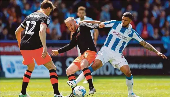  ?? REUTERS PIC ?? Huddersfie­ld’s Nahki Wells (right) and Sheffield Wednesday’s Barry Bannan vie for the ball at the John Smith’s Stadium yesterday.