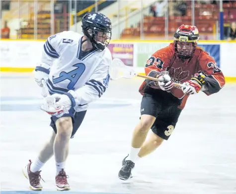  ?? JULIE JOCSAK/STANDARD STAFF ?? Liam Hamm of the St. Catharines Athletics tries to keep the ball away from Brody Munro of the Whitby Warriors in junior A lacrosse action at the Jack Gatecliff Arena in St. Catharines on Wednesday.