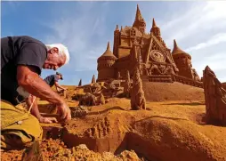  ?? (Yves Herman/Reuters) ?? A SAND CARVER works on a sculpture during ‘Disney Sand Magic’ festival in Ostend, Belgium, in June.