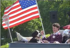  ?? PETE BANNAN - MEDIANEWS GROUP ?? When else can you bring your dog to graduation? Radnor High School graduate Austin Stanley kicks back after receiving his diploma in ceremonies in front of the school Friday morning. Stanley, a lacrosse standout, has plans to attend Catholic University of America.