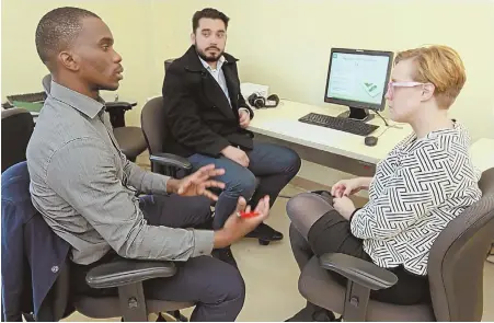  ?? STAFF PHOTO BY STUART CAHILL ?? RETRAINING: Kristan Fitah, right, works with students Kostov M. Jacques, left, and Sebastian Rodriguez in the Careers in Banking and Finance Class at the Center for Workforce Developmen­t.