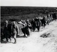  ??  ?? POWs from Britain and France carry injured comrades as they march through France during the First World War