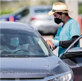  ?? AL DIAZ adiaz@miamiheral­d.com ?? A patient prepares to be vaccinated at the Miami-Dade County COVID-19 Community-Based Testing & Vaccinatio­n Site at Tropical Park.