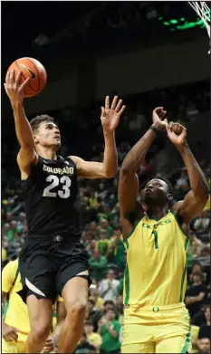  ?? AMANDA LOMAN — THE ASSOCIATED PRESS ?? Colorado forward Tristan da Silva drives to the basket as Oregon center N’faly Dante defends March 7 in Eugene, Ore. Colorado won 79-75.