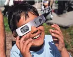  ?? MANDI WRIGHT/DETROIT FREE PRESS ?? Kai Hysell, 7, of Bloomfield Hills watches the solar eclipse with his family at the Cranbrook Institute of Science in Bloomfield Hills on Monday.