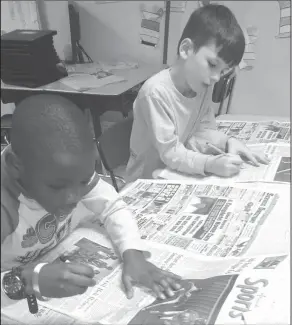  ??  ?? Pronouns: In Stacy Gulick’s class, Yocum second graders Justin Obiozo and Ashton Sullivan read the El Dorado News-Times and search for pronouns.