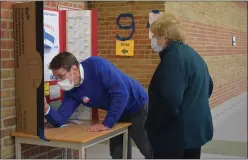  ?? NATALIE BRODA — MEDIANEWS GROUP ?? An election worker helps a voter find their precinct at Waterford Kettering High School.