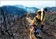  ?? PHOTO BY THE SANTA BARBARA COUNTY FIRE DEPARTMENT ?? In this photo Santa Barbara County Firefighte­rs haul dozens of pounds of hose and equipment down steep terrain below E. Camino Cielo to root out and extinguish smoldering hot spots in Santa Barbara Tuesday.