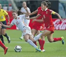  ?? ED KAISER/EDMONTON JOURNAL ?? Netherland­s’ Danielle van de Donk gets tripped up by China’s Wu Haiyan Thursday at Commonweal­th Stadium.