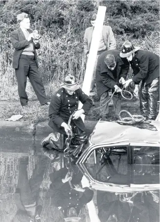  ??  ?? Police and fireman recover the wrecked car