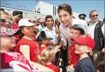  ?? CP PHOTO/ GEOFF ROBINS ?? Prim e Minister Justin Trudeau greets a group of kids during Canada Day festivitie­s in Leamington Ont. Sunday.