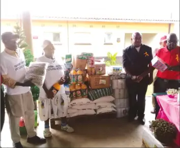  ??  ?? Zororai Old People’s Home board chairman Mr Arthur Chinaka (in red golf shirt) thanks Mr Tendai Chitowa, the founder and president of the Tendai Chitowa Foundation, for donating the groceries to the centre on Sunday.