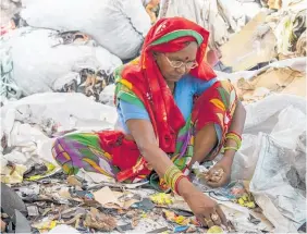  ??  ?? Agra is known for its shoe-manufactur­ing industry. Here a woman sifts through piles of leather and other material offcuts, sorting them into piles.