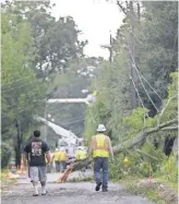  ?? HERBERT, AP GERALD ?? Workers clear trees from power lines Sunday in Biloxi, Miss., in the aftermath of Hurricane Nate.