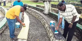  ?? PHOTO BY GARETH DAVIS ?? Mayor of Port Antonio Paul Thompson (right) applying a fresh coat of paint to the Neville Antonio Park in Port Antonio, while chief engineer Wayne Mitchell assists.