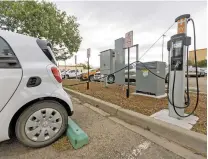  ?? PHOTOS BY LUIS SÁNCHEZ SATURNO/THE NEW MEXICAN ?? An electric car charges Wednesday in the parking lot at the Public Employee Retirement Associatio­n Building in Santa Fe.