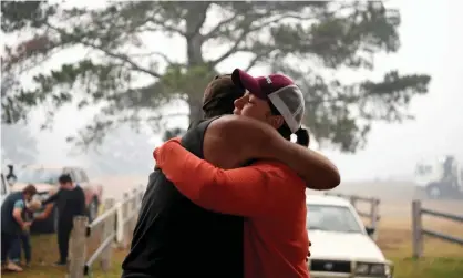  ?? Photograph: Tracey Nearmy/Reuters ?? John Aish, who lost his home, is hugged at the Cobargo evacuation centre. An extra $40m from the government may be used for basics including utility bills, clothing, petrol and bus tickets.